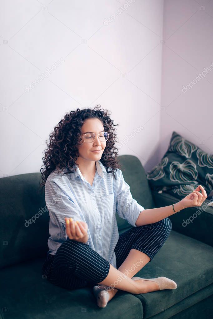 side view shot of slim woman meditating indoors