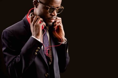 adam ve boynunda kırmızı kulaklıklarla resmi kıyafetler