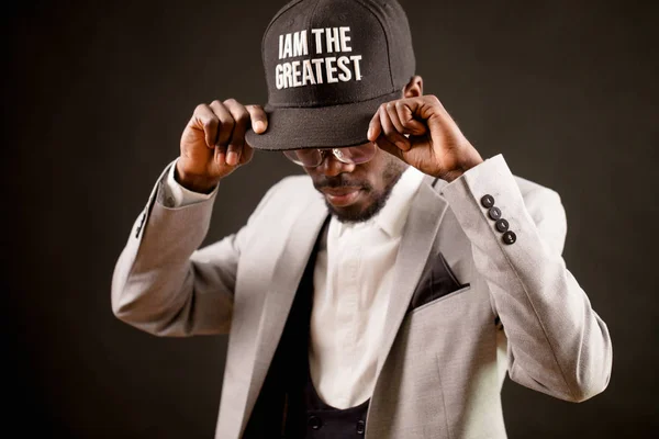 modest Afro man with a cap with inscription I am the greatest