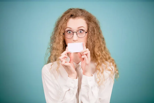 Jovem loira cobrindo boca com folha de papel cartão de visita — Fotografia de Stock