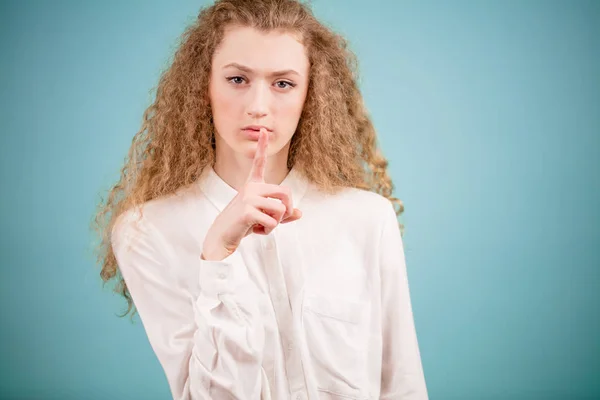 Close up shot of female with long curly hair saying to become quiet — Stock Photo, Image