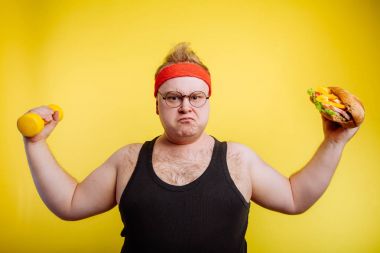 Şişman, aç adam, pazılarını hamburger ve halterle göster.