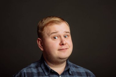 Kafkasyalı şişman adam kameraya bakıyor.