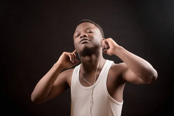 Varón africano joven escuchando música con los ojos cerrados — Foto de Stock