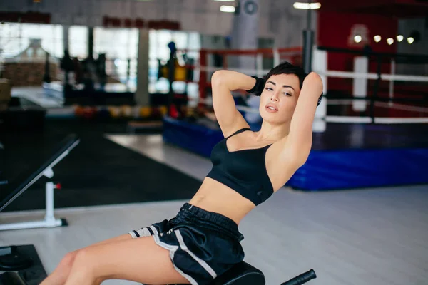 Belle femme en haut noir et short faisant des sit-ups à la salle de gym — Photo