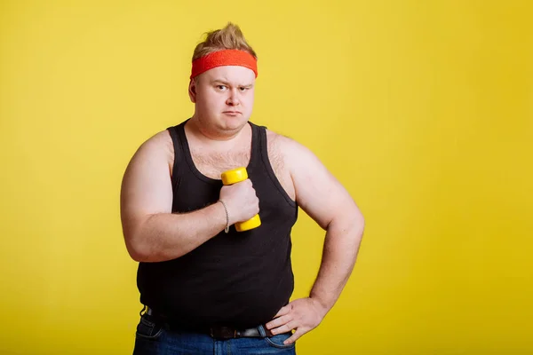 Hombre gordo con mancuerna sobre fondo amarillo. Motivación para las personas gordas —  Fotos de Stock