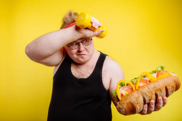 Unaveni tlustý muž pocení při zvedání burger — Stock fotografie