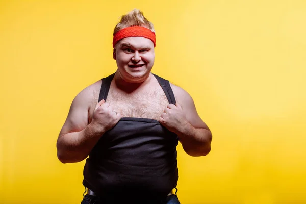 Hombre gordo con diadema roja y camisa negra grita sobre fondo oscuro —  Fotos de Stock