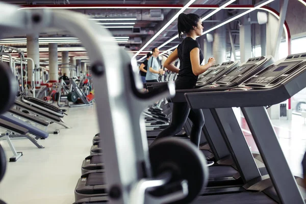 Wanita muda fit berjalan di atas treadmill — Stok Foto