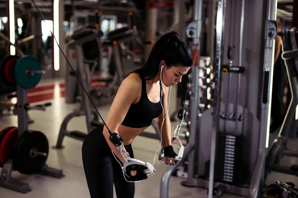 Jimnastik salonunda egzersiz makinesi kablolu yayınıyla egzersiz yapmaya hazır kadın. — Stok fotoğraf