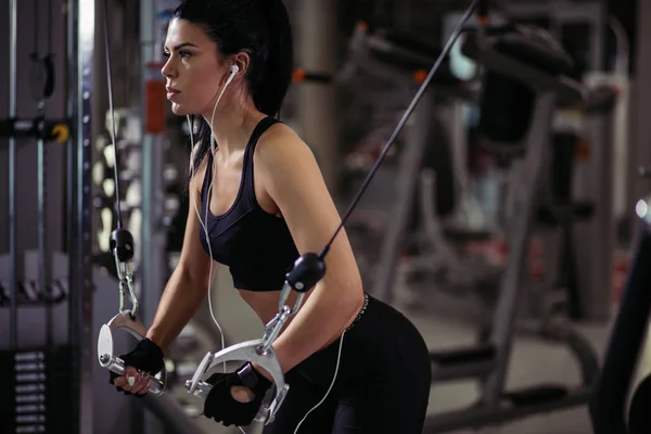 Femme en forme exécuter l'exercice avec la machine d'exercice Cable Crossover dans la salle de gym — Photo