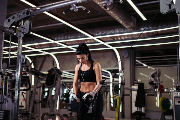 Femme en forme exécuter l'exercice avec la machine d'exercice Cable Crossover dans la salle de gym — Photo