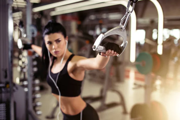 Ejercicio de mujer con Cable Crossover en el gimnasio. concéntrate en la mano chica. enfoque selectivo — Foto de Stock