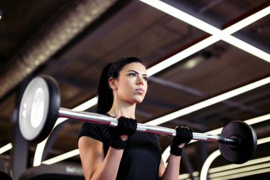 Fitness, genç bayana yaklaş. Beden eğitimi için pazılarını al.