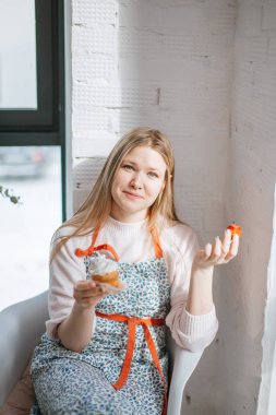 Pudra kadında önlük ejoying strauberry ile onun sadece pişmiş kek tasarlamak.