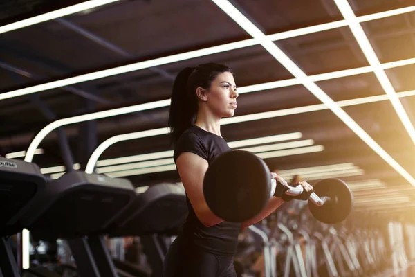 fitness, close up of young woman pick up for biceps in gym