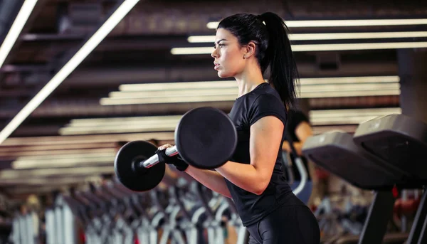 Fitness, Nahaufnahme einer jungen Frau, die im Fitnessstudio nach Bizeps greift — Stockfoto