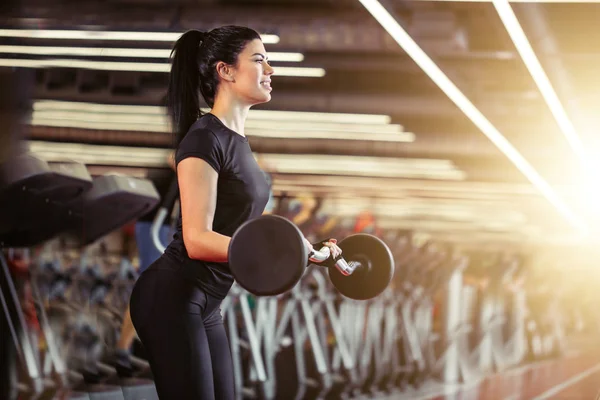 Fitness, Nahaufnahme einer jungen Frau, die im Fitnessstudio nach Bizeps greift — Stockfoto