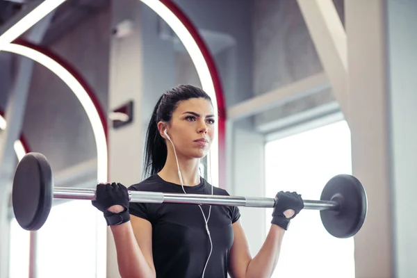 Fitness, Nahaufnahme einer jungen Frau, die im Fitnessstudio nach Bizeps greift — Stockfoto