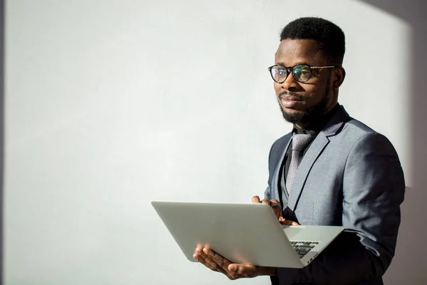 Afrikanska medarbetare bär glasögon och använder laptop i office — Stockfoto