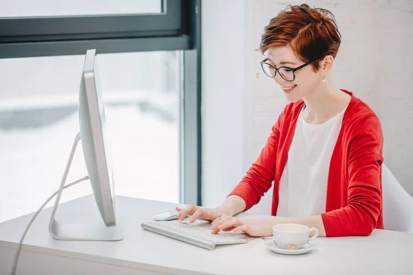 Typen op toetsenbord in heldere kantoor zakenvrouw — Stockfoto