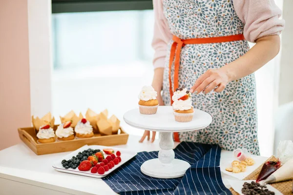 Panadería Chef decoración cupcakes con bayas en la mesa en la cocina — Foto de Stock