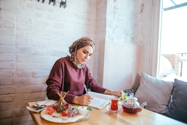 Muslimská žena pracující v kavárně — Stock fotografie