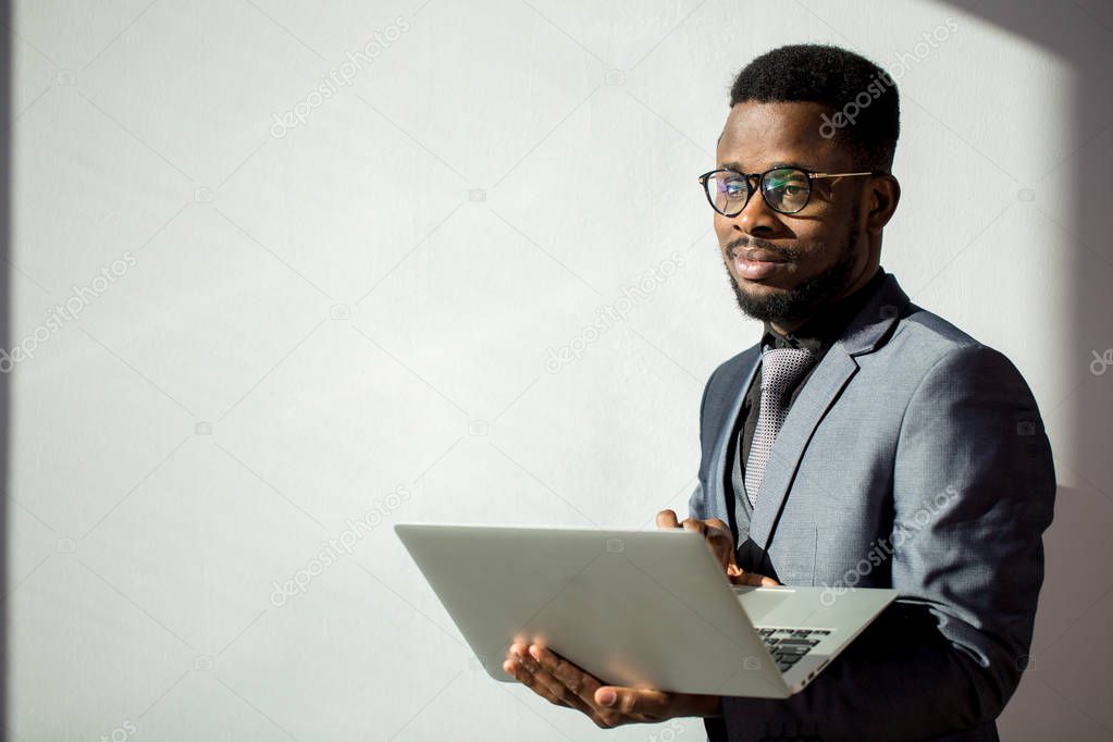 african coworker wearing glasses and using laptop in office
