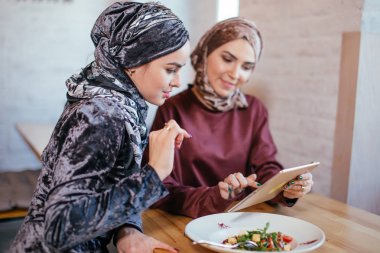 İki Müslüman kadın kafe, dükkan online elektronik tablet kullanma