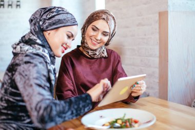 İki Müslüman kadın kafe, dükkan online elektronik tablet kullanma