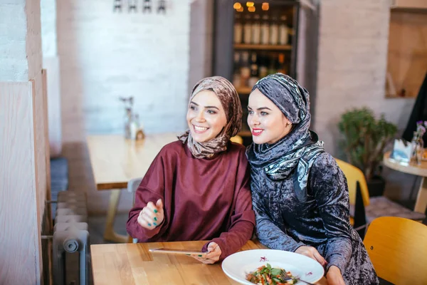 Dos mujeres musulmanas en la cafetería, comprar en línea usando tableta electrónica — Foto de Stock