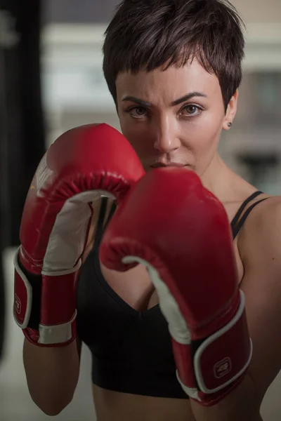 Yakışıklı spor kadın kırmızı boks eldivenleri kamera bakıyor — Stok fotoğraf