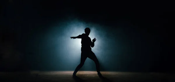 Young man in casual clothers showing his dance on the dark street — Stock Photo, Image