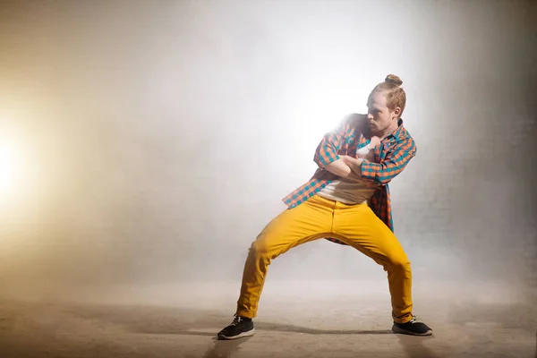 Jonge man met gekruiste armen en benen uit elkaar wacht op zijn solo in dans — Stockfoto