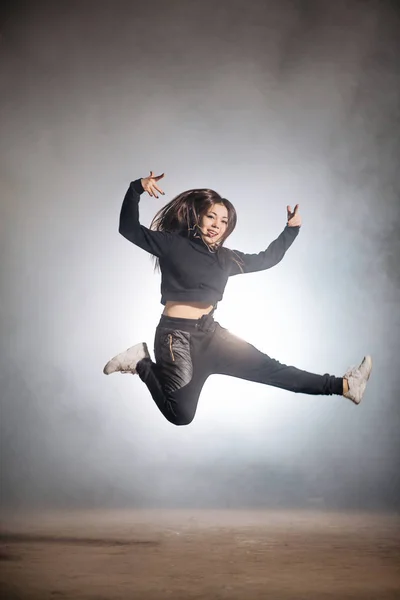 Žena v černém clothers se snaží udělat spilts ve vzduchu — Stock fotografie