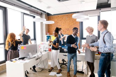 Neşeli öğrenciler takım yaratıcı ofiste yüksek beş yapıyor