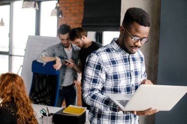 Mutlu genç adam onun laptop çalışma gözlüklü