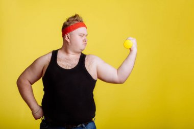 şişman adam sarı arka plan üzerinde halter ile. Şişman insanlar için motivasyon