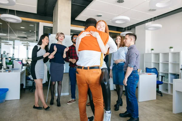 office romance concept. two mixed race lovers hugging at work.