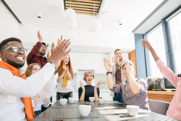 Chefin und ihr Team sitzen am Tisch und klatschen in die Hände — Stockfoto