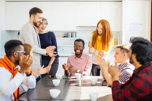 Equipo joven ambicioso ofreciendo felicitaciones a la moda africana masculina — Foto de Stock