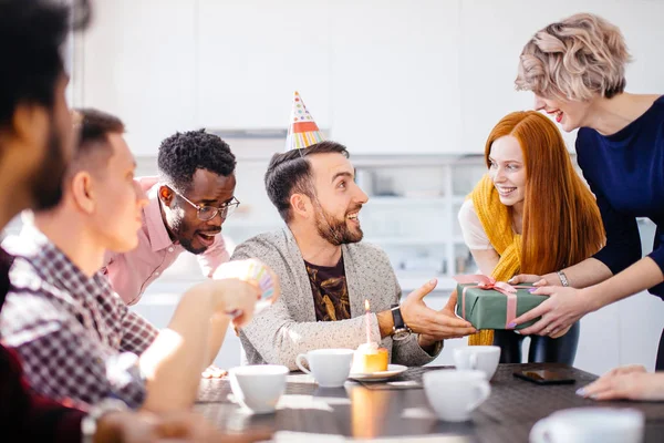 Närbild porträtt av ung kvinna med kort rättvis hår ger gåva t kollega — Stockfoto