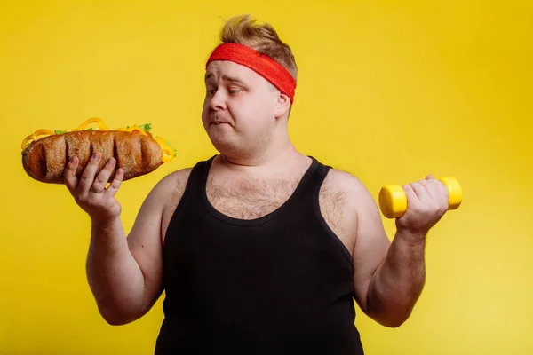 Fat man choise between sport and fastfood — Stock Photo, Image