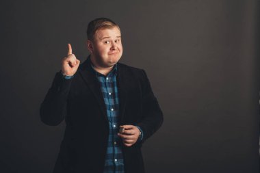 Şişman genç adam işaret ediyor