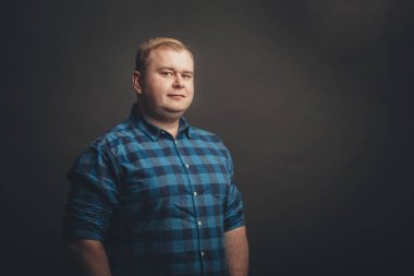 Kafkasyalı şişman adam kameraya bakıyor.