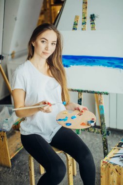 Kadın sanatçı resmini şövale onun atölyesinde yağlı boya ile resim