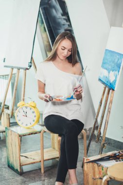 Zaman oluşturmak için. Çekici kadın deniz scape boyama sırasında fullface poz