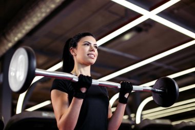 Fitness, genç bayana yaklaş. Beden eğitimi için pazılarını al.