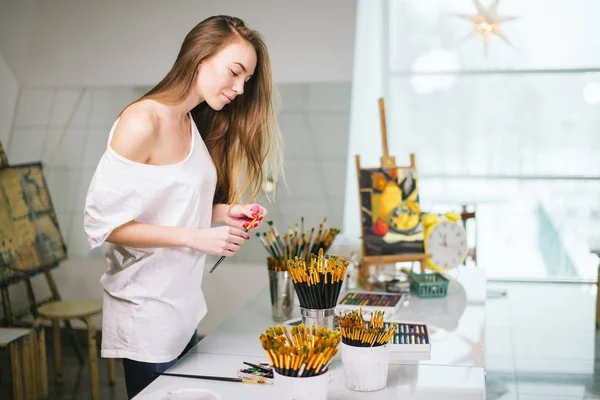 Natural beauty teacher painter in her studio preparing to an art class