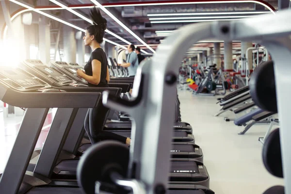 Wanita muda fit berjalan di atas treadmill — Stok Foto